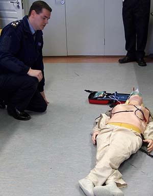 Garda Victor Isdell su automatiniu išoriniu defibriliatoriumi (AED).