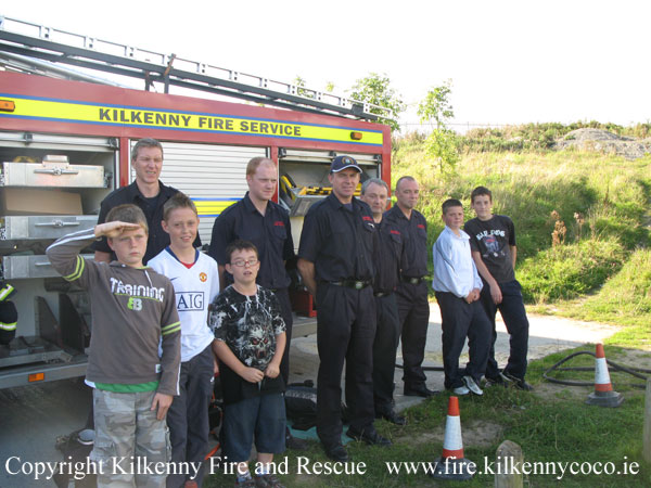 KCAN - Los niños posan con el equipo de bomberos