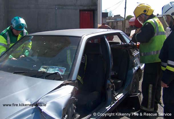 Feuerwehrleute machen am Unfallort Platz in einem Fahrzeug